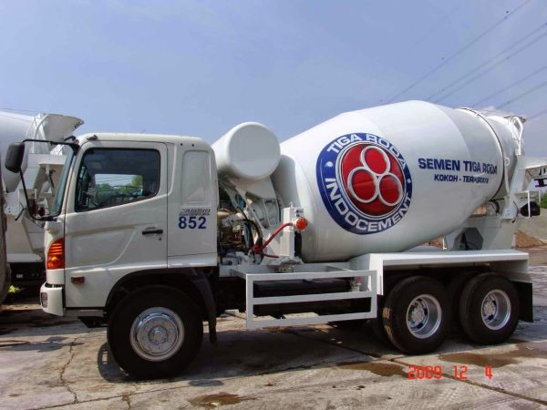 Deskripsi Produk: Beton Cor Readymix Mutu K-100 Beton Cor Readymix Mutu K-100 adalah jenis beton siap pakai yang diproduksi secara terpusat di batching plant modern kami. Kami memastikan setiap campuran beton dibuat dengan presisi tinggi, menggunakan agregat (pasir dan kerikil), semen Portland berkualitas, air, dan bahan tambahan yang diukur secara akurat melalui sistem komputerisasi. Proses ini menjamin konsistensi mutu yang seragam di setiap meter kubik beton yang Anda pesan. Angka K-100 pada mutu beton ini mengacu pada kuat tekan karakteristik minimal 100 kg/cm² yang akan dicapai beton setelah 28 hari pengeringan dan perawatan. Ini menandakan bahwa beton ini memiliki kekuatan yang memadai untuk berbagai aplikasi yang tidak menahan beban struktural yang sangat berat, namun tetap memerlukan kekokohan dan durabilitas. Beton ini diantar langsung ke lokasi proyek Anda menggunakan truk mixer khusus, menjaga kualitas dan konsistensinya tetap optimal hingga tiba. Ini adalah solusi efisien yang menghilangkan kebutuhan pengadukan di lokasi, meminimalkan limbah, dan mempercepat proses pengecoran proyek Anda. 💰 Harga Beton Cor Readymix Mutu K-100 (Per M³) Kami berkomitmen untuk memberikan harga beton cor readymix mutu K-100 yang paling kompetitif dan transparan. Berikut adalah tabel estimasi harga yang dapat Anda jadikan acuan awal untuk perencanaan anggaran Anda. Mutu Jenis Campuran Tipe Truk Harga per M³ (Franco Batching Plant)* Keterangan K-100 Fly Ash (FA) Truk Standar (7–9 m³) Rp 780.000 – Rp 850.000 Beton dengan campuran fly ash, cocok untuk struktur dengan beban ringan. K-100 Non Fly Ash (NFA) Truk Standar (7–9 m³) Rp 795.000 – Rp 865.000 Beton tanpa campuran fly ash, untuk preferensi spesifik. K-100 Fly Ash (FA) MiniMix (3–4 m³) Rp 900.000 – Rp 980.000 Truk molen kecil, ideal untuk lokasi dengan akses terbatas. K-100 Non Fly Ash (NFA) MiniMix (3–4 m³) Rp 915.000 – Rp 995.000 Truk molen kecil, tanpa fly ash, untuk akses terbatas. Export to Sheets *Catatan Penting: Harga di atas adalah estimasi rata-rata pasar dan tidak mengikat. Harga final akan disesuaikan berdasarkan: Lokasi Pengiriman: Biaya transportasi (mobilisasi truk mixer) akan dihitung berdasarkan jarak dari batching plant terdekat ke lokasi proyek Anda. Volume Pemesanan: Volume total yang Anda pesan dapat memengaruhi harga per meter kubik (pemesanan volume besar mungkin mendapatkan harga lebih efisien). Aksesibilitas Lokasi: Kondisi jalan menuju proyek (sempit, menanjak, padat) dapat memengaruhi tipe truk yang digunakan (MiniMix seringkali lebih mahal per m³ tetapi vital untuk akses terbatas). Jam Pengiriman: Pengiriman di luar jam operasional normal (misalnya dini hari) mungkin dikenakan biaya tambahan. Harga belum termasuk biaya sewa pompa beton atau layanan tambahan lainnya (seperti vibrator beton, finishing). 🏗️ Kegunaan Utama Beton Cor Readymix Mutu K-100 Meskipun mutu K-100 dikategorikan sebagai beton non-struktural atau struktural ringan, fleksibilitas dan efisiensinya membuatnya ideal untuk berbagai aplikasi di proyek Anda: Pengecoran Lantai Kerja (Lean Concrete): Ini adalah aplikasi paling umum. K-100 ideal sebagai lapisan dasar yang tipis di atas tanah sebelum pengecoran pondasi, sloof, atau plat lantai, memastikan permukaan yang rata dan bersih. Lantai Non-Struktural Ringan: Cocok untuk lantai garasi mobil pribadi, lantai gudang dengan beban ringan, area pejalan kaki, atau lantai teras rumah yang tidak menahan beban berat. Rabat Beton: Sangat tepat untuk pengecoran jalan lingkungan, gang perumahan, atau area parkir dengan lalu lintas kendaraan ringan, memberikan permukaan yang solid dan awet. Pengisi Urugan (Filling): Dapat digunakan sebagai material pengisi untuk meratakan permukaan tanah, mengisi rongga, atau dasar untuk paving block. Pondasi Ringan: Untuk bangunan non-permanen atau struktur ringan seperti pos jaga, pagar, atau bangunan pelengkap taman, K-100 dapat dipertimbangkan jika daya dukung tanah sudah memadai. Spesifikasi & Komposisi Campuran Beton K-100 (Mix Design) Kualitas Beton Cor Readymix Mutu K-100 kami terjamin berkat komposisi yang presisi. Berikut adalah rincian standar untuk 1 meter kubik (m³) beton K-100 (komposisi dapat bervariasi sedikit tergantung batching plant dan jenis campuran FA/NFA): Semen: Sekitar 247 kg Pasir: Sekitar 870 kg Kerikil Split: Sekitar 998 kg Air: Sekitar 215 liter Fly Ash (untuk FA): Dapat bervariasi, hingga 10-20% dari berat semen. Water/Cement Ratio (FAS): Sekitar 0,87 (Rasio air terhadap semen yang dikontrol ketat untuk workability dan kekuatan optimal). Kepadatan: Sekitar 2.200 kg/m³ Komposisi ini dirancang untuk menghasilkan beton dengan workability yang baik, memungkinkan kemudahan penuangan dan pemadatan, serta mencapai kuat tekan karakteristik 100 kg/cm² pada usia 28 hari. Keunggulan Memilih Jasa Kami untuk Beton Cor Readymix Mutu K-100 Mempercayakan kebutuhan beton cor readymix mutu K-100 Anda kepada kami berarti Anda memilih mitra yang berkomitmen pada kualitas dan efisiensi: Produk Asli & Terpercaya: Kami hanya menyediakan beton cor readymix mutu K-100 yang 100% asli dari produsen terkemuka, menjamin standar kualitas yang terbukti. Harga Kompetitif & Transparan: Dapatkan penawaran harga beton cor readymix K-100 terbaik di pasar. Kami mengedepankan transparansi biaya tanpa ada yang tersembunyi. Jaminan Mutu Terkontrol: Setiap pengiriman beton melalui quality control ketat di batching plant, memastikan mutu K-100 yang Anda pesan sesuai standar teknis. Pengiriman Tepat Waktu: Kami memiliki armada truk mixer yang siap mengantarkan beton ke lokasi proyek Anda sesuai jadwal, meminimalkan downtime. Jangkauan Luas: Kami melayani pengiriman beton cor readymix K-100 ke seluruh wilayah Jabodetabek dan sekitarnya. Pelayanan Prima & Responsif: Tim profesional kami siap memberikan konsultasi teknis, membantu perhitungan volume beton, dan memastikan proses pemesanan hingga pengiriman berjalan lancar. Dukungan Solusi Terintegrasi: Jika Anda membutuhkan layanan tambahan seperti sewa pompa beton untuk mempermudah pengecoran, kami juga dapat menyediakannya sebagai bagian dari solusi terintegrasi kami. 📌 Tips Pemesanan Beton K-100 Untuk memastikan kelancaran proyek Anda, perhatikan beberapa tips penting berikut saat memesan beton cor readymix mutu K-100: Pemesanan: Lakukan pemesanan minimal 1–2 hari sebelum tanggal pengecoran yang diinginkan. Untuk volume besar atau lokasi dengan akses sulit, disarankan untuk memesan lebih awal. Survey Lokasi: Pastikan akses jalan menuju lokasi proyek Anda dapat dilalui truk mixer dengan aman (minimal 5 meter lebar jalan untuk truk standar, 3 meter untuk MiniMix). Informasikan kepada kami jika ada hambatan atau akses terbatas agar kami dapat merekomendasikan tipe truk yang tepat. Konsultasi: Jangan ragu untuk mendiskusikan kebutuhan beton Anda dengan tim kami. Kami siap memberikan rekomendasi yang tepat terkait volume, jadwal, dan jenis campuran beton untuk hasil yang optimal. Pembayaran: Pembayaran biasanya dilakukan setelah survei lokasi (jika diperlukan) dan sebelum proses pengecoran dimulai, sesuai dengan kesepakatan yang tertera dalam penawaran. Jangan biarkan kualitas beton menjadi kendala atau sumber kekhawatiran dalam pembangunan Anda. Percayakan kebutuhan beton cor readymix mutu K-100 Anda kepada kami untuk proyek yang efisien, ekonomis, dan berkualitas. Hubungi Kami Sekarang untuk Proyek Anda! Untuk informasi lebih lanjut, konsultasi gratis mengenai kebutuhan beton Anda, atau untuk mendapatkan penawaran harga beton cor readymix mutu K-100 terbaik untuk proyek Anda, jangan ragu untuk menghubungi kami. Tim kami siap melayani Anda dengan profesionalisme dan responsibilitas tinggi. Anwar Telepon/WhatsApp: 0813-1711-6767 Website: www.artha-konstruksi.com
